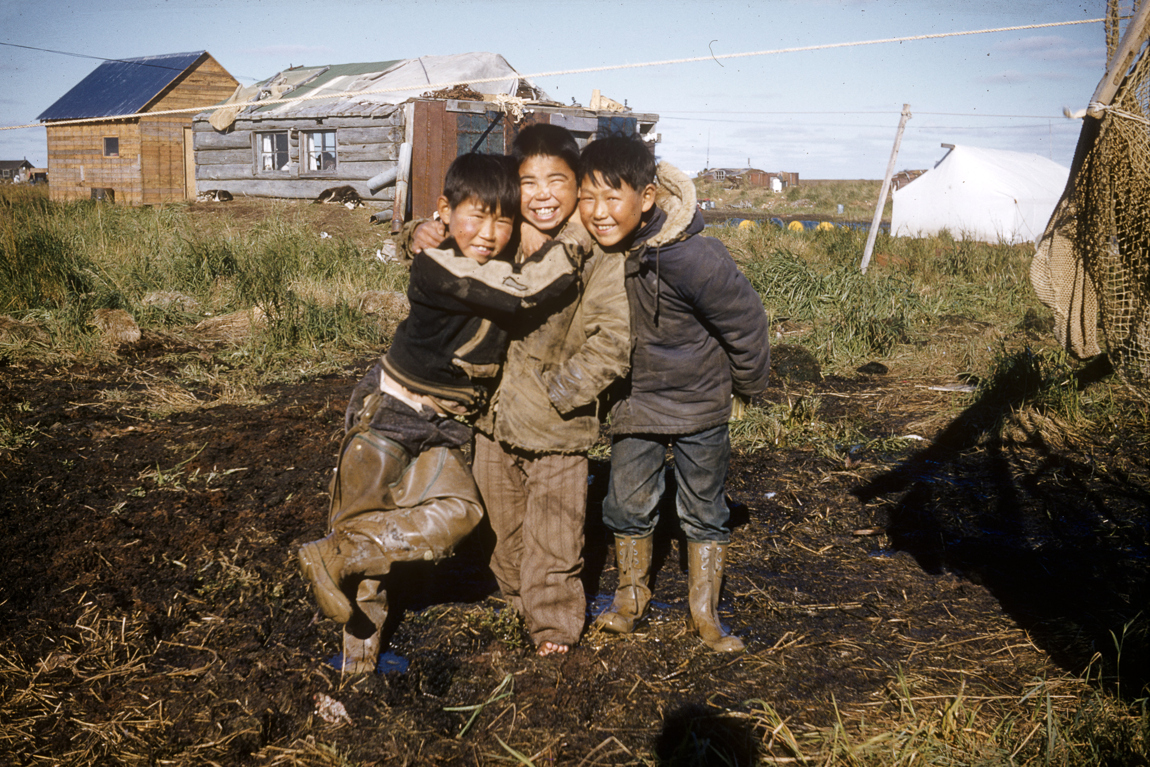 Muddy playtime in Newtok , c. 1957. Digital reproduction from 35mm slide. Christine Heller Collection, Anchorage Museum, B1991.011.0584.